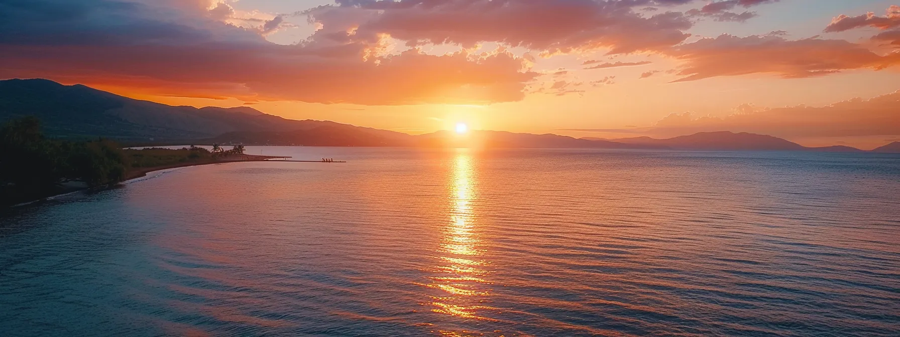 a breathtaking coastal sunset illuminates the sky with vibrant hues of orange and pink, reflecting off the tranquil ocean waves and creating a serene atmosphere.