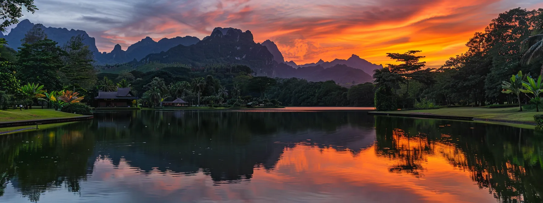 a breathtaking sunrise casts vibrant hues of orange and pink across a serene mountain lake, reflecting the majestic peaks and lush greenery that surround its tranquil waters.