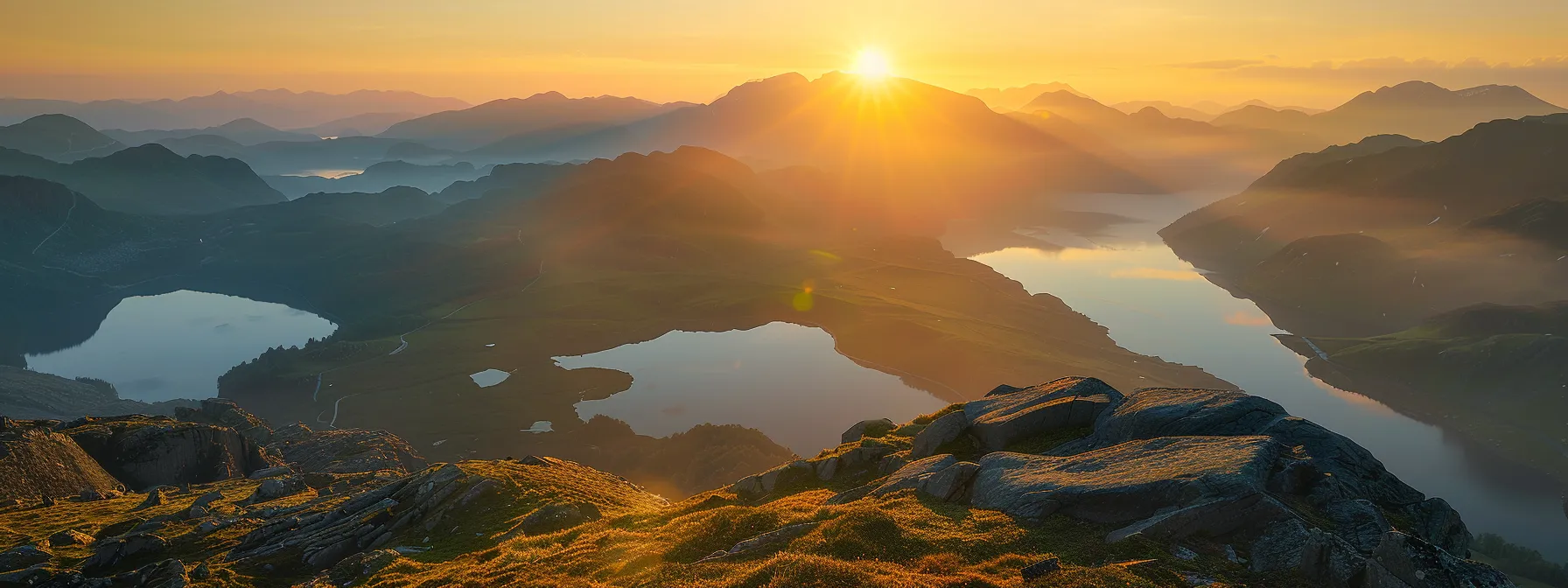 a breathtaking sunrise illuminates a serene mountain landscape, casting golden hues over mist-covered valleys and reflecting off a tranquil lake, evoking a sense of peace and grandeur.
