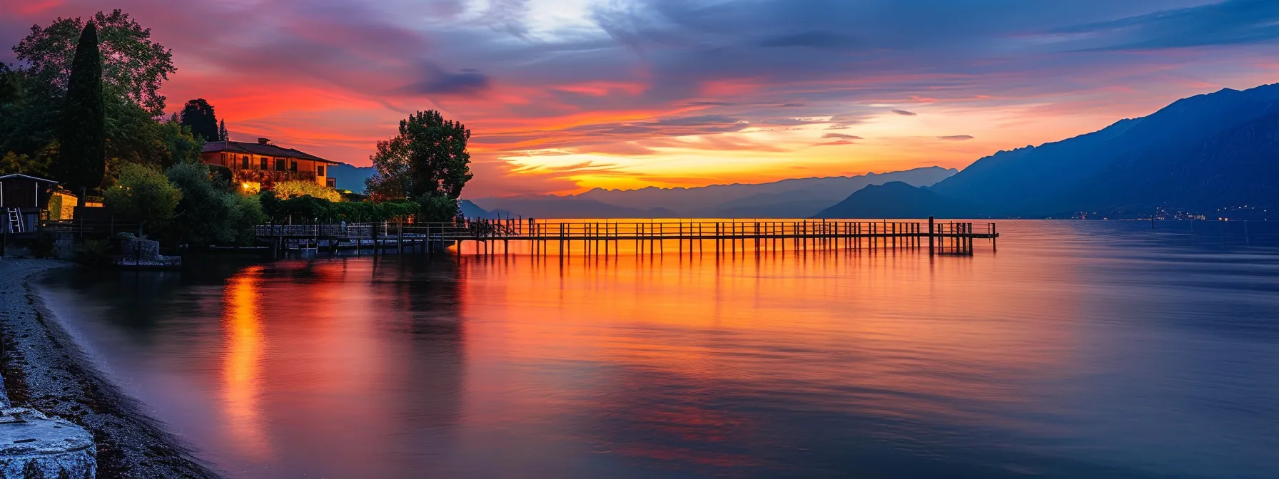 a breathtaking sunset casts vibrant hues of orange and pink across a tranquil lake, reflecting the stunning colors onto the calm water surface, creating a serene and picturesque landscape.