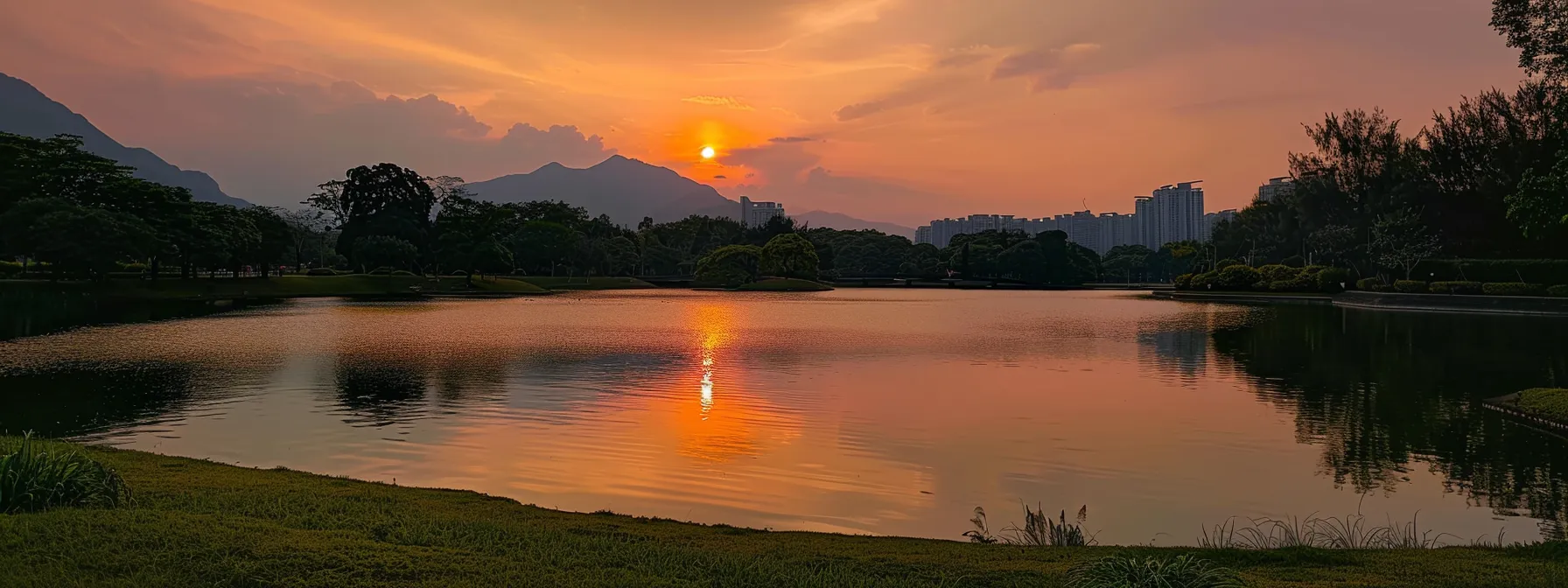 a breathtaking sunset casts vibrant hues of orange and pink across a serene lake, reflecting the majestic silhouette of distant mountains under a clear, twilight sky.