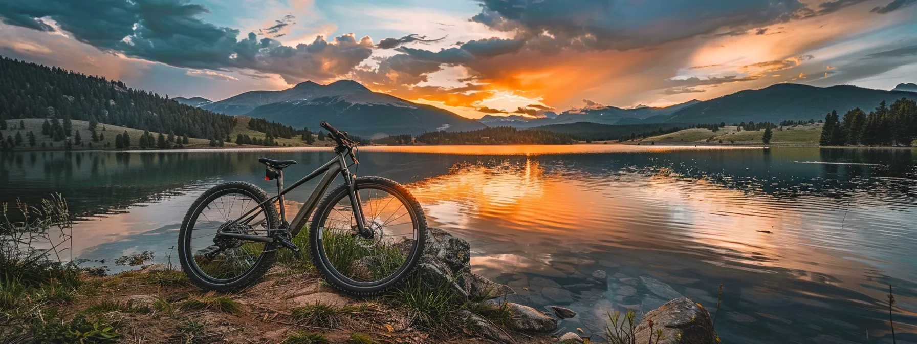 a vibrant sunset bathes a serene landscape in warm hues, illuminating a tranquil lake surrounded by majestic mountains reflecting perfectly on the water's surface.