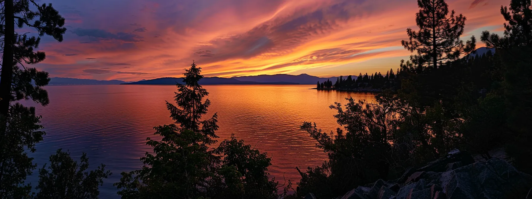 a vibrant sunset casts a golden glow over a tranquil lake, reflecting the vivid hues of orange and pink in the sky, with silhouetted trees framing the serene waters.