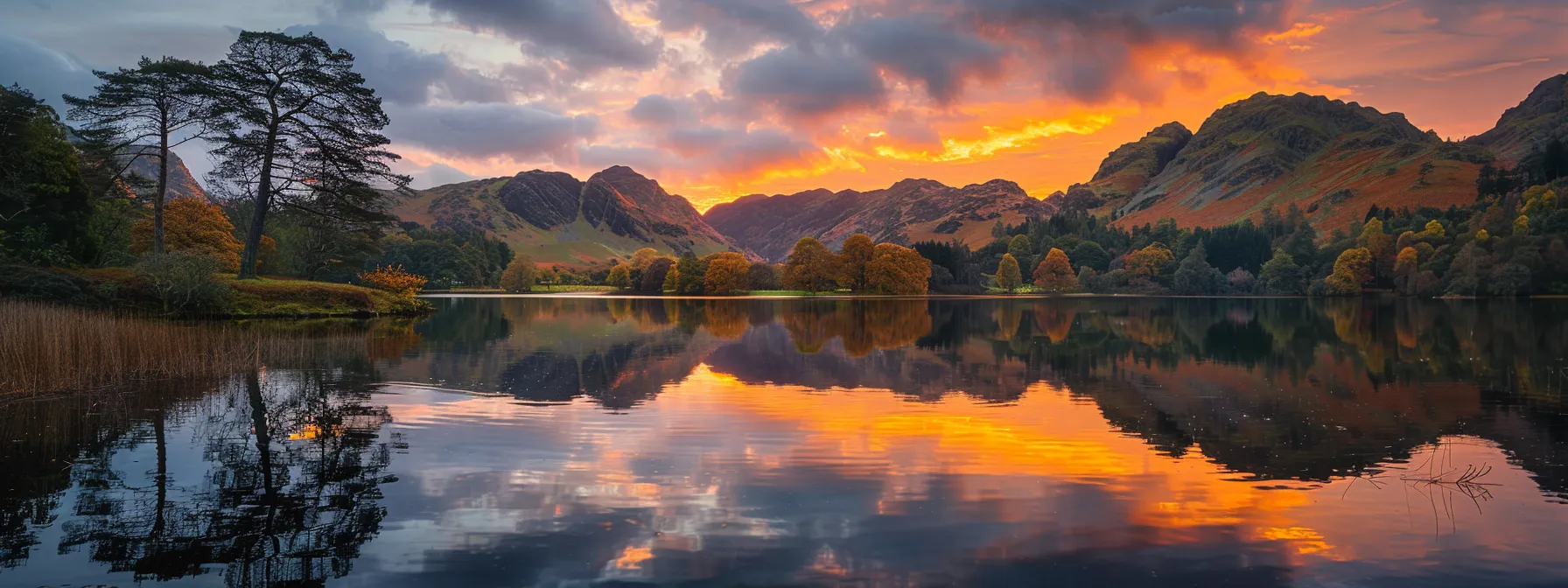 a vibrant sunset casts golden hues over a serene lake, reflecting the silhouetted mountains and lush trees surrounding the tranquil waters.
