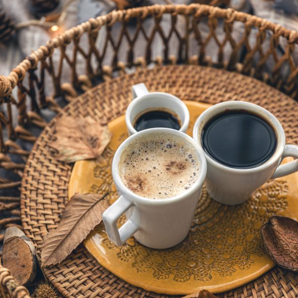 Cozy home composition with coffee cups, leaves and a plaid.